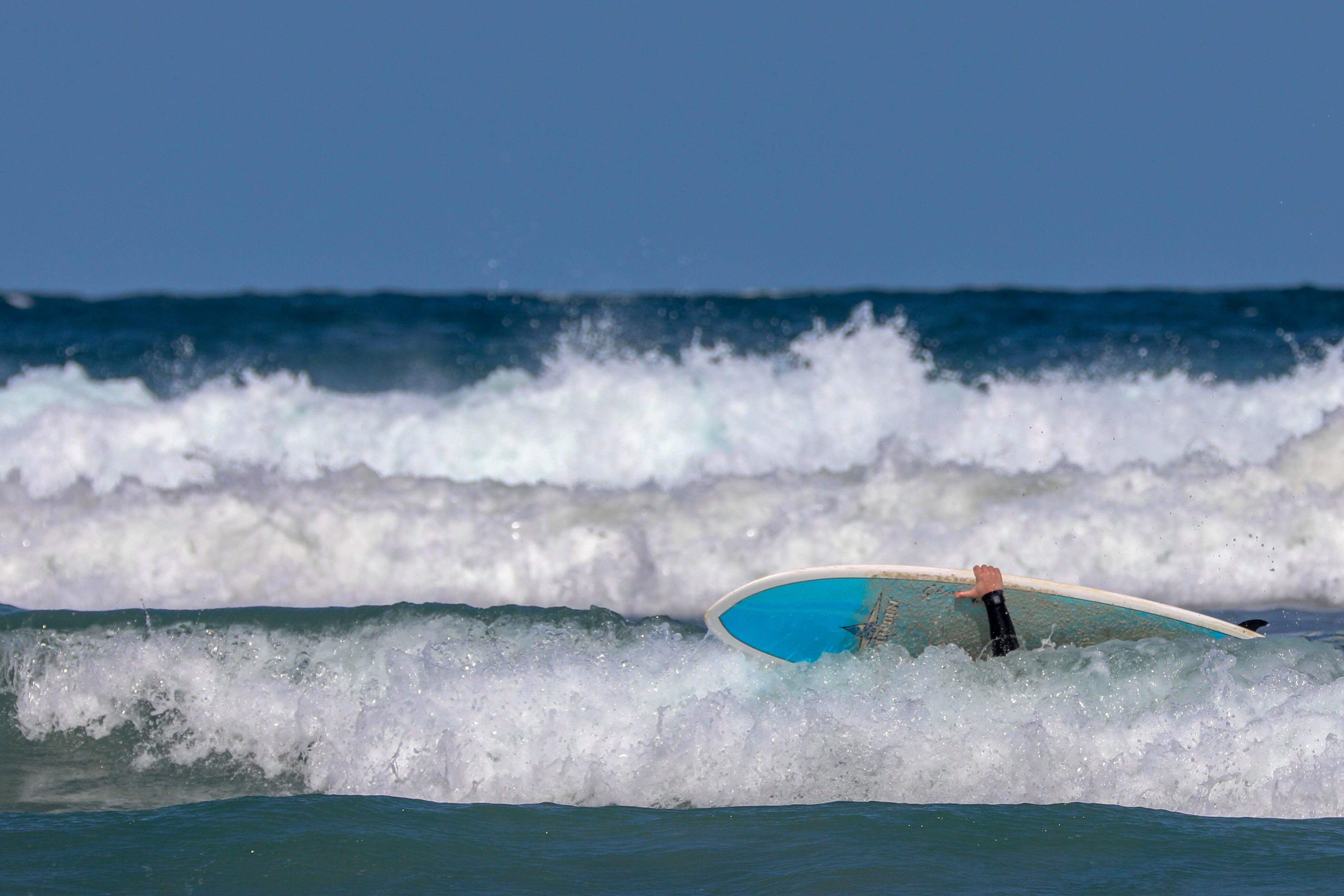 Xisco w białej wodzie w swojej pierwszej szkole surfingu, trzymający się deski